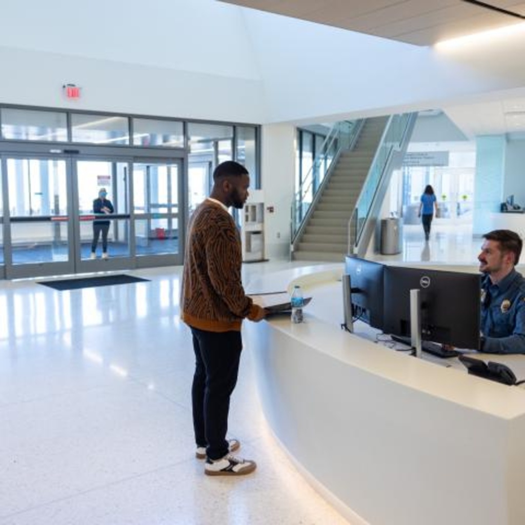 an interaction at a front desk between a patient and a health care staff member