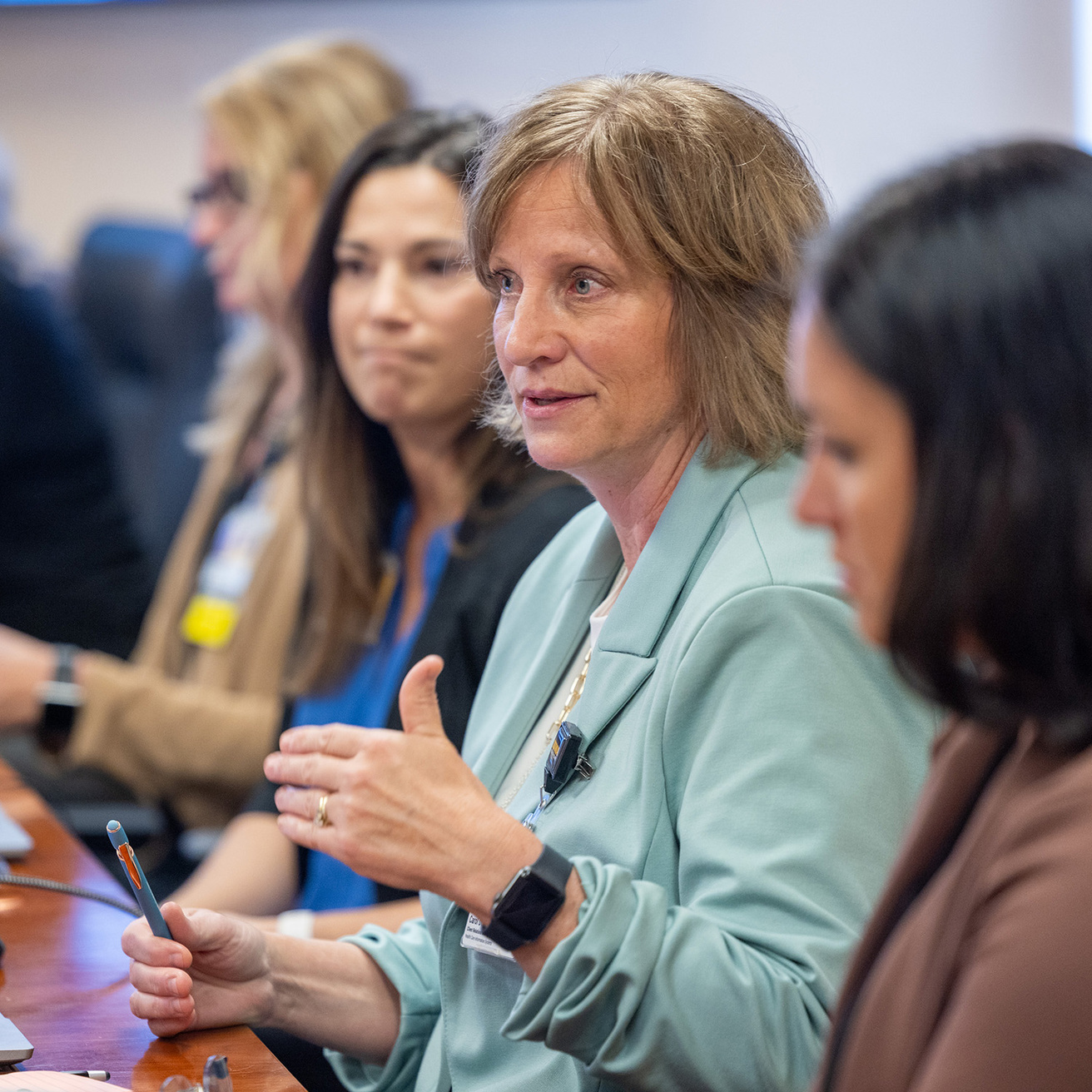 a woman gestures during a meeting in a conference room