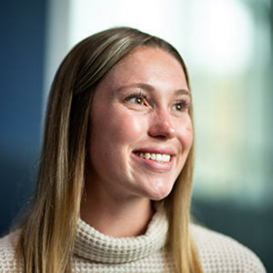 A woman smiling while looking off into the distance