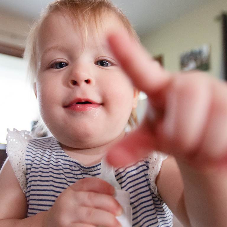 a toddler pointing at the camera