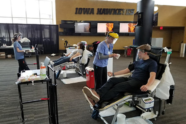 health care professionals and participants at a blood drive held at the university of iowa's carver-hawkeye arena