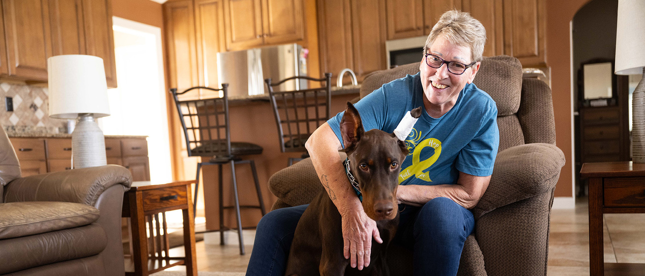 a woman sits in her living room with her Doberman puppy
