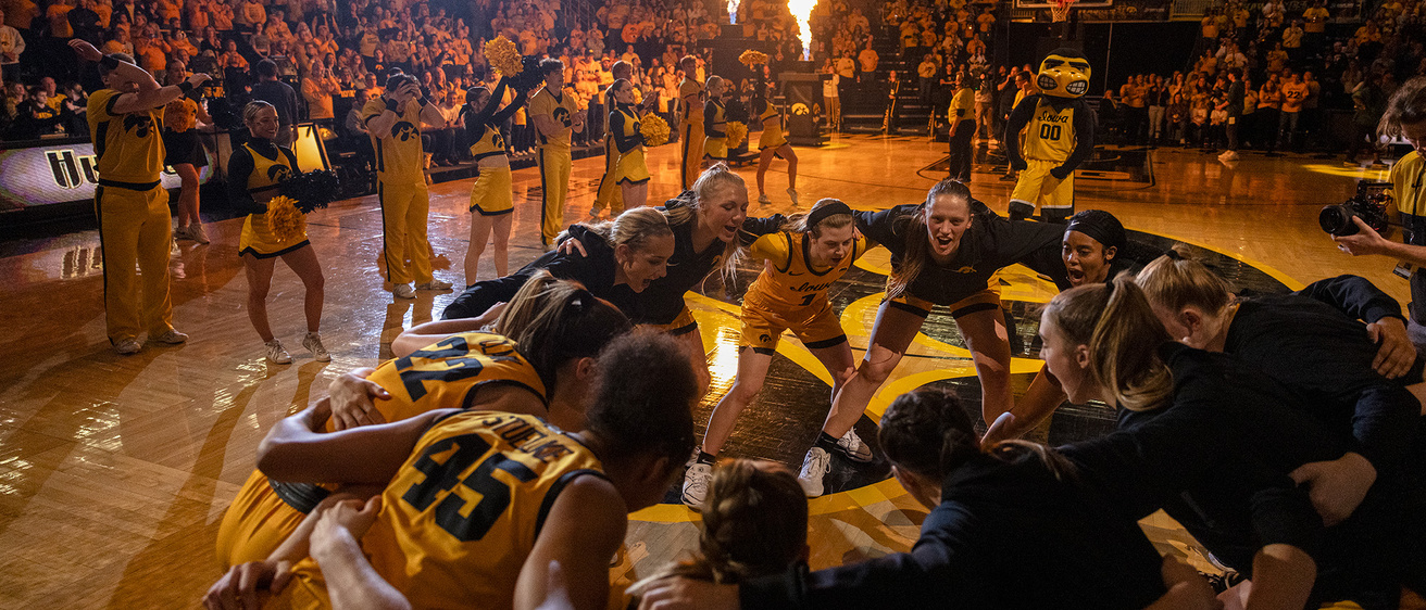 the iowa women's basketball team huddles up at center court at the end of fiery pregame festivities