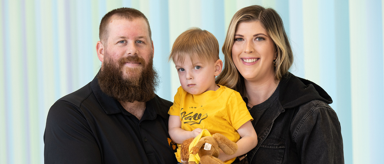 parents smiling while holding their young child