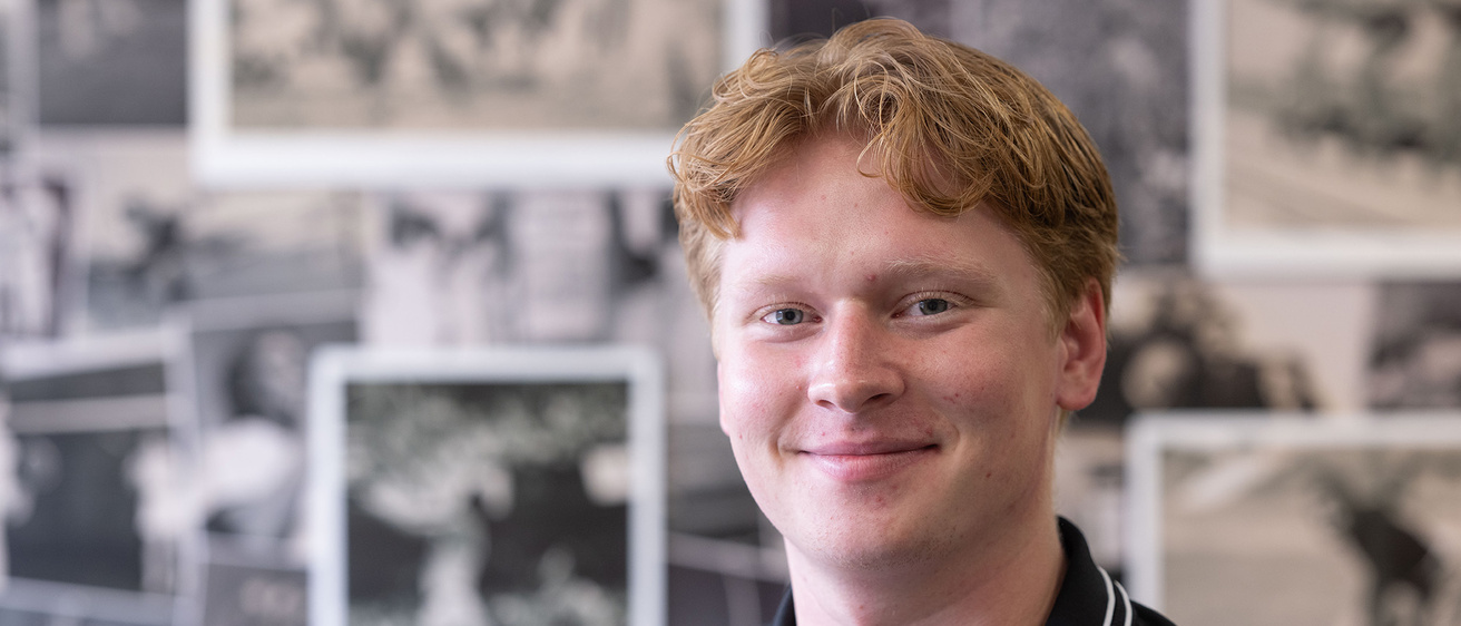 A man posing for a portrait in front of a photo wall