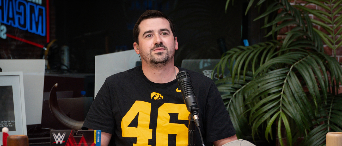 A man sitting at a desk speaking into a microphone