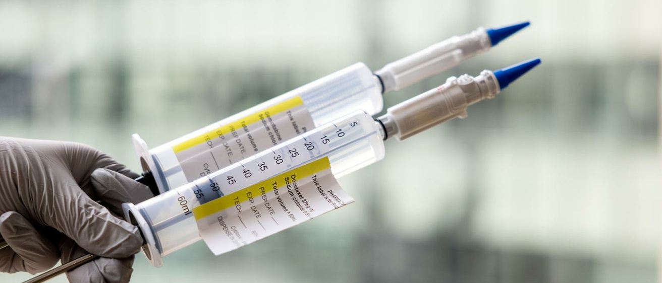 Two syringes being held up