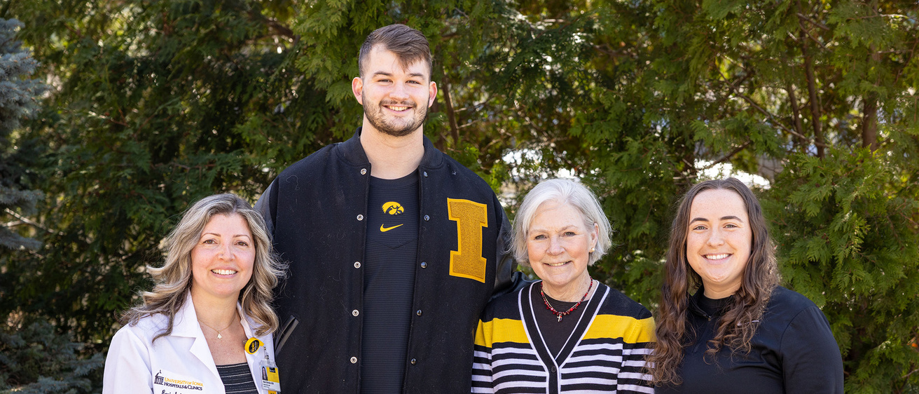 A group of four hawkeyes standing together smiling