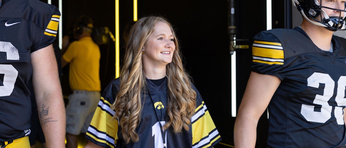 A girl holding hands with two football players