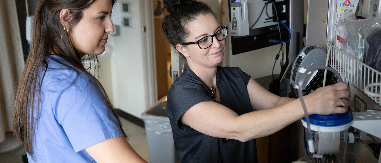 A nurse demonstrates job to student employee