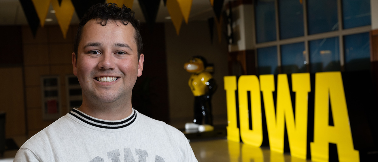 A man standing in front of a Herky statue smiling