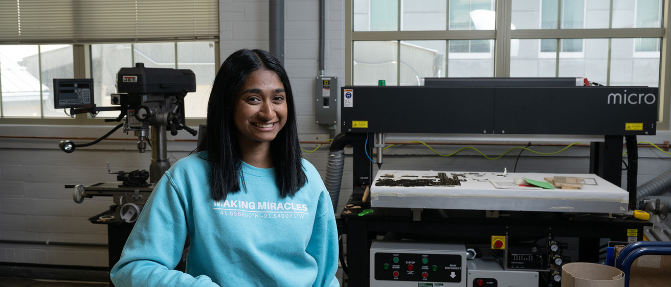 A woman standing in a workshop smiling