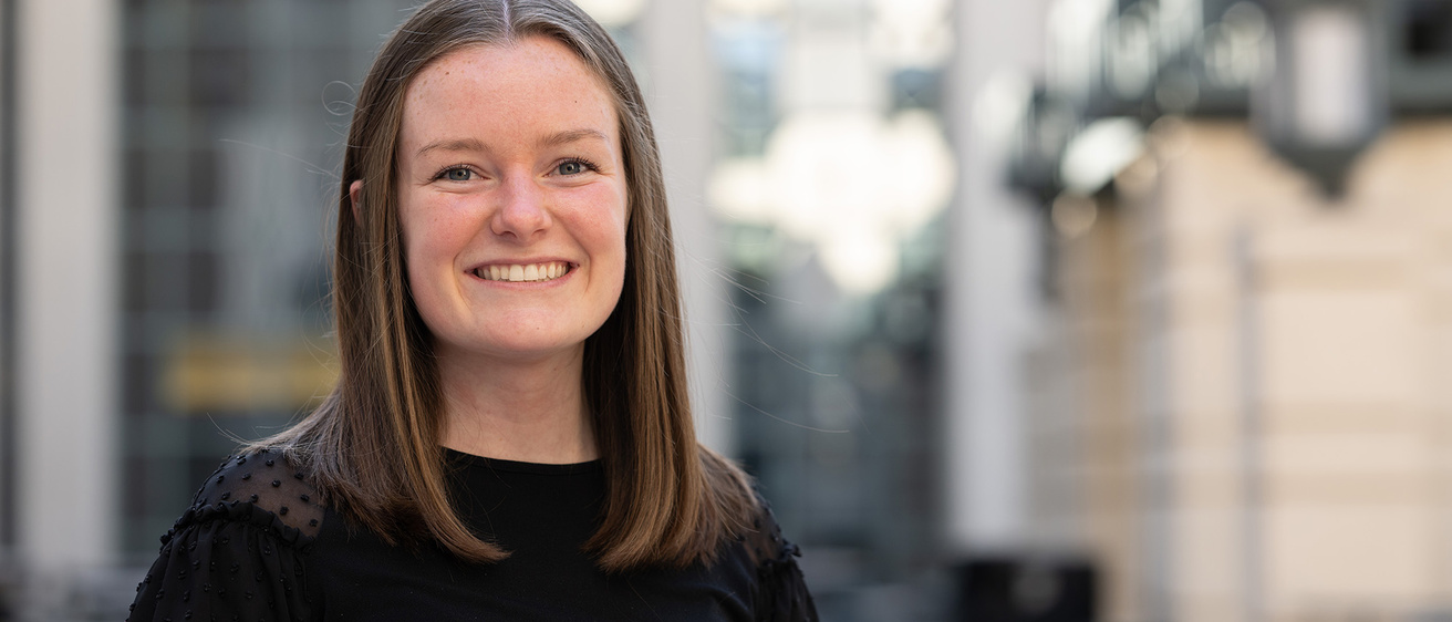 A woman smiling with a city background