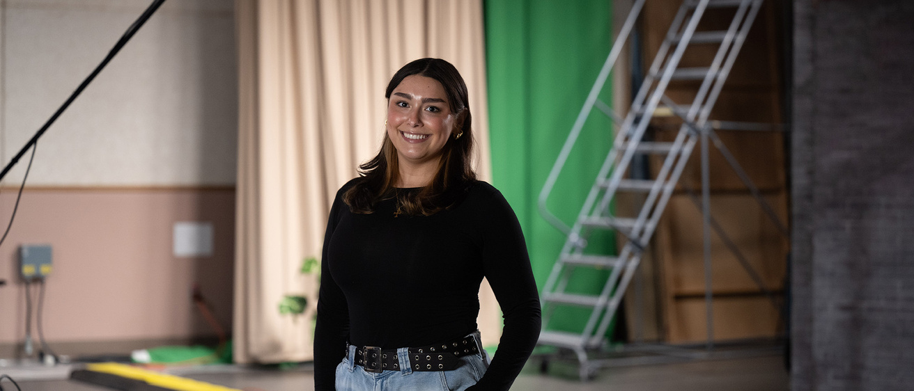 A woman standing in a studio smiling