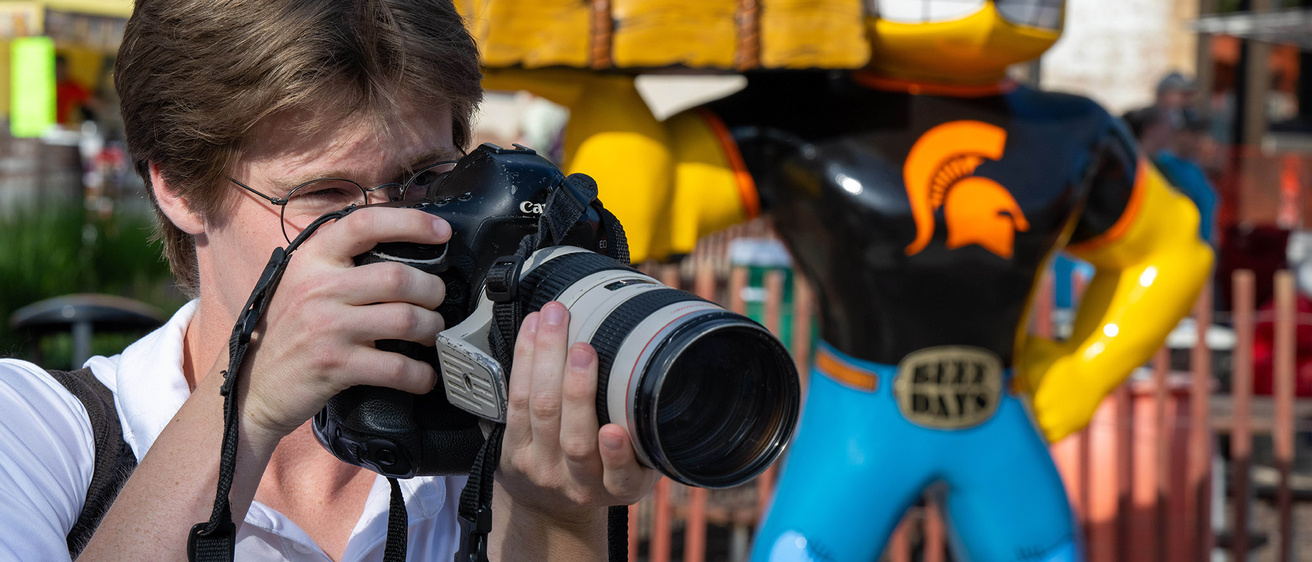A person standing with a camera up to their face