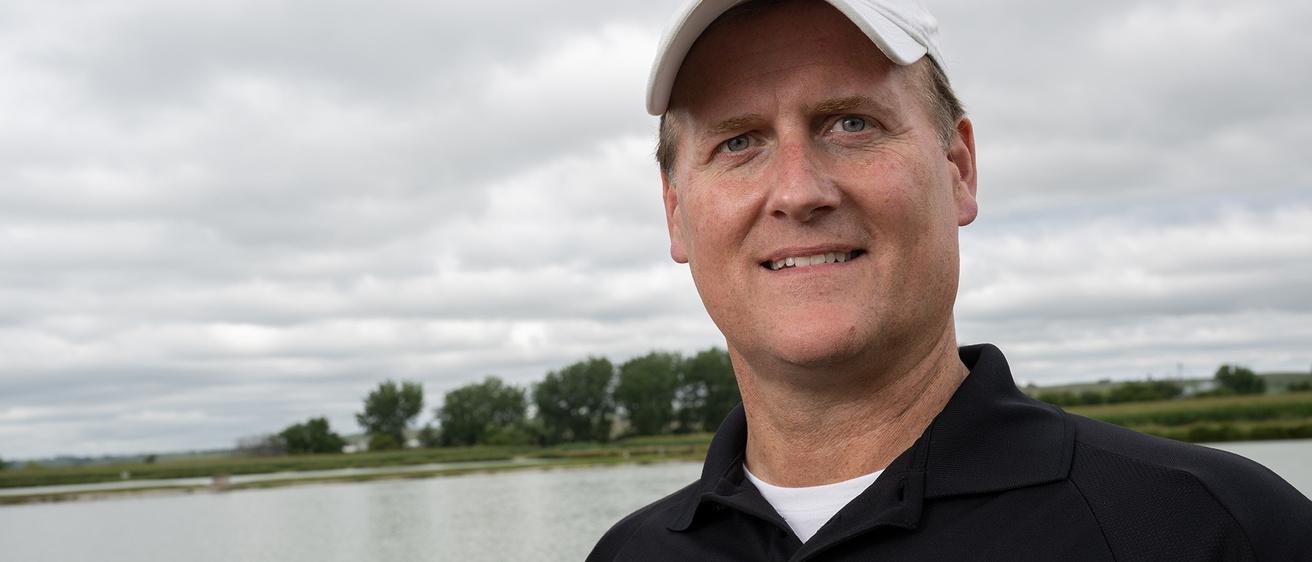 A man smiling with a lake in the background