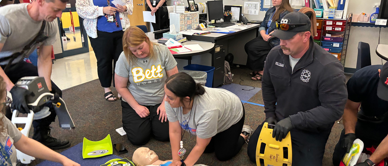 A woman performing CPR on a dummy