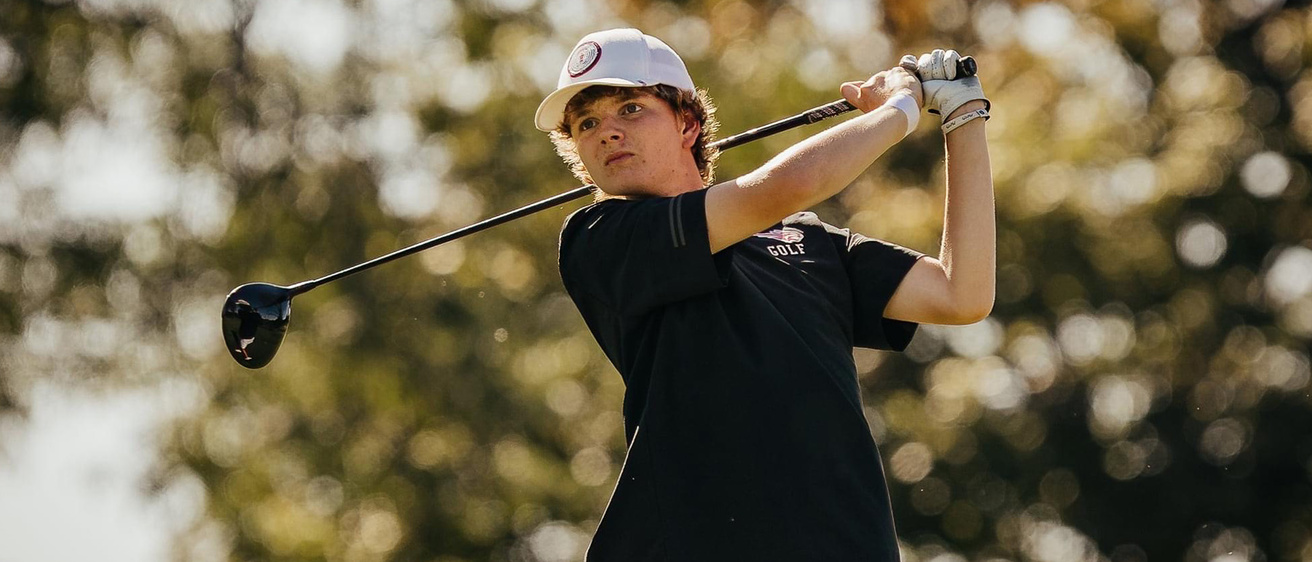 A boy swinging a golf club