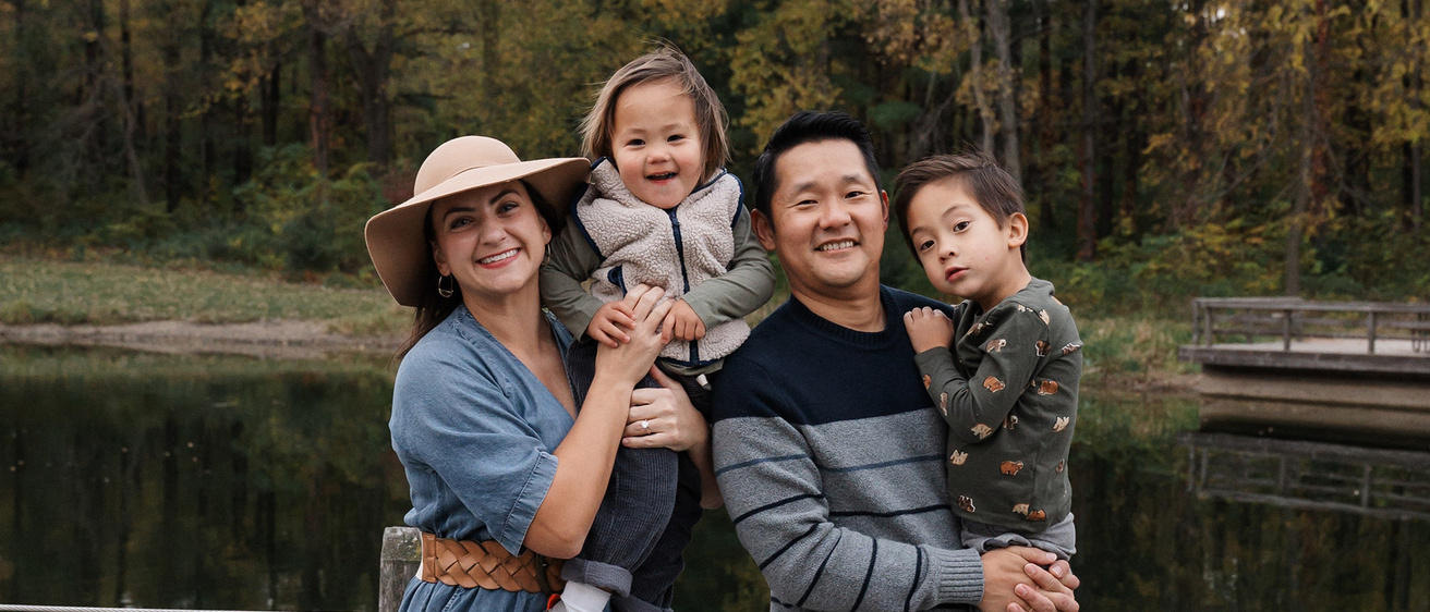 A family standing together near a lake