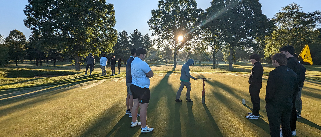 A group of people standing on a putting green