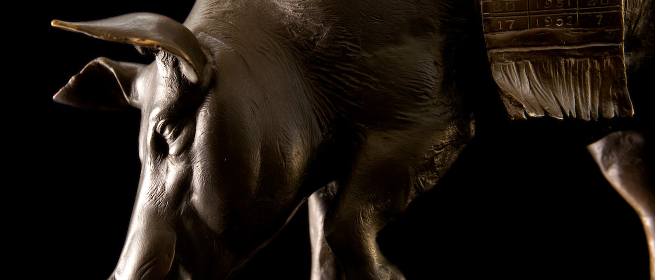 A side angle of a bronze statue of a pig