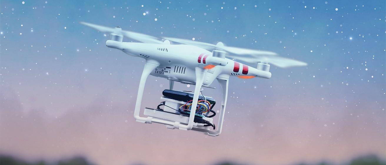 a drone flying amid a star-filled sky in a grassy and wooded landscape