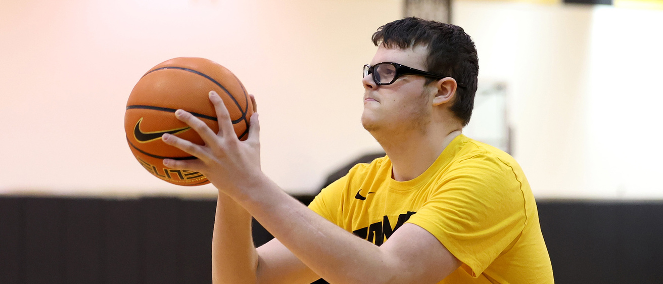 a young man shooting a basketball