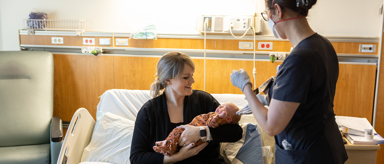 a mother and child and a health care professional in a hospital setting