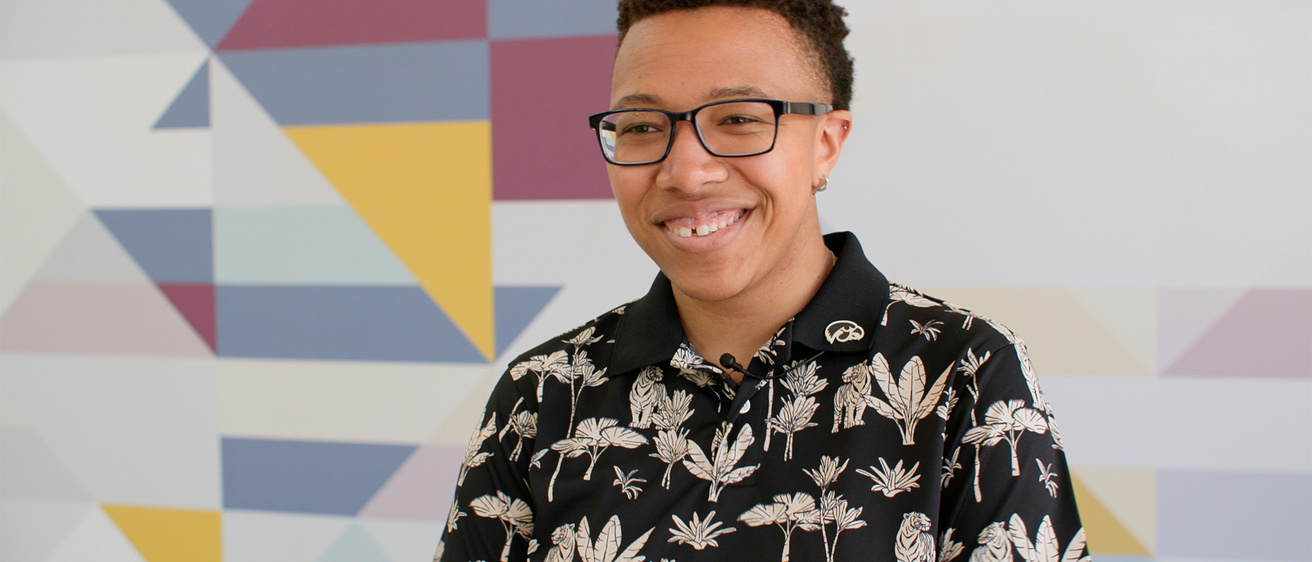 A woman standing in front of a patterned wall
