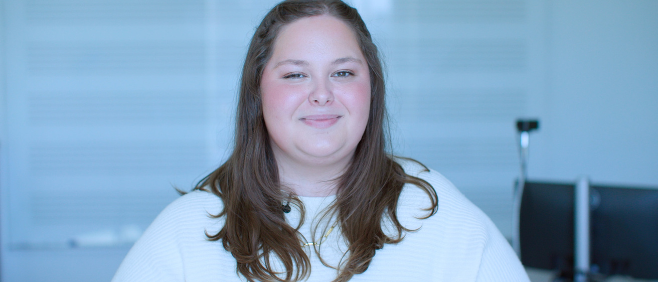 A woman standing in front of a whiteboard while smiling