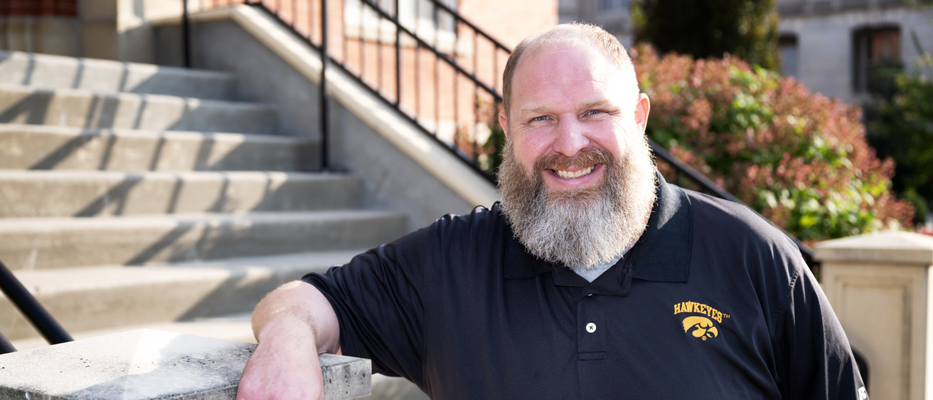 A man leaning on a set of stairs post