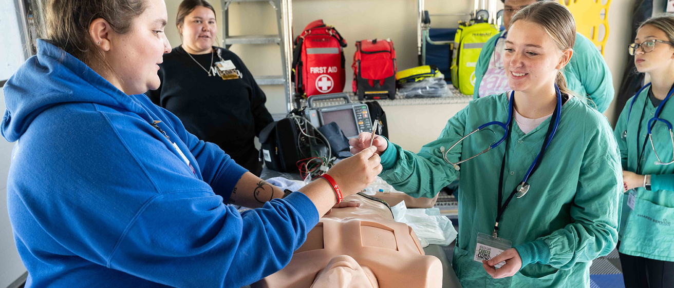 A group of people practicing on a dummy