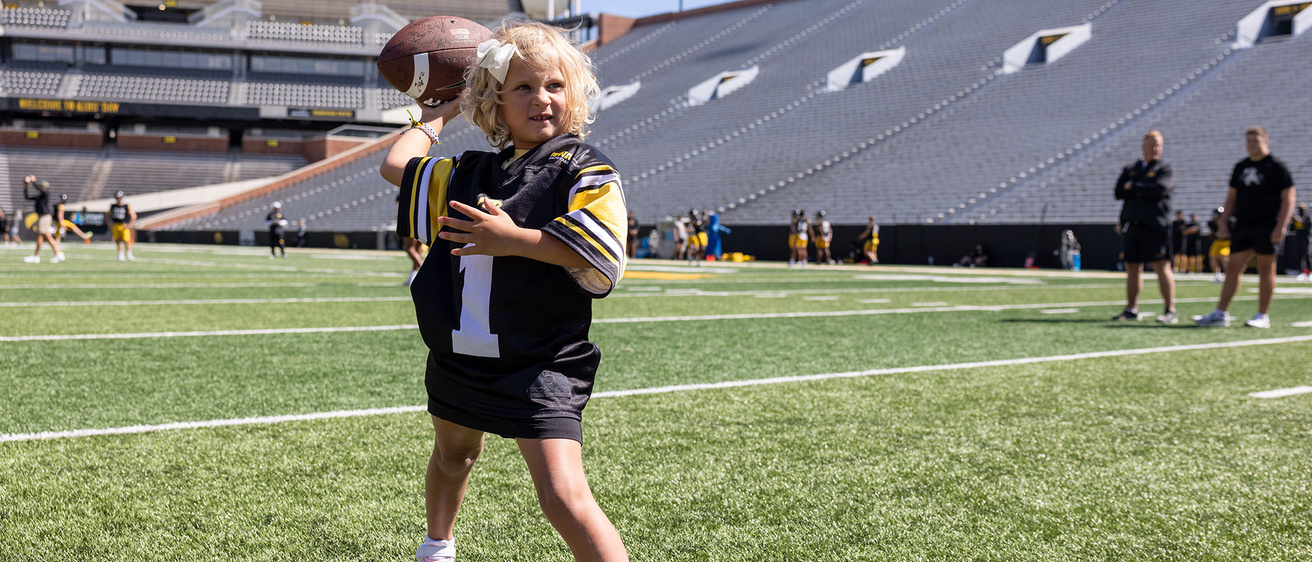 A young girl getting ready to throw a football