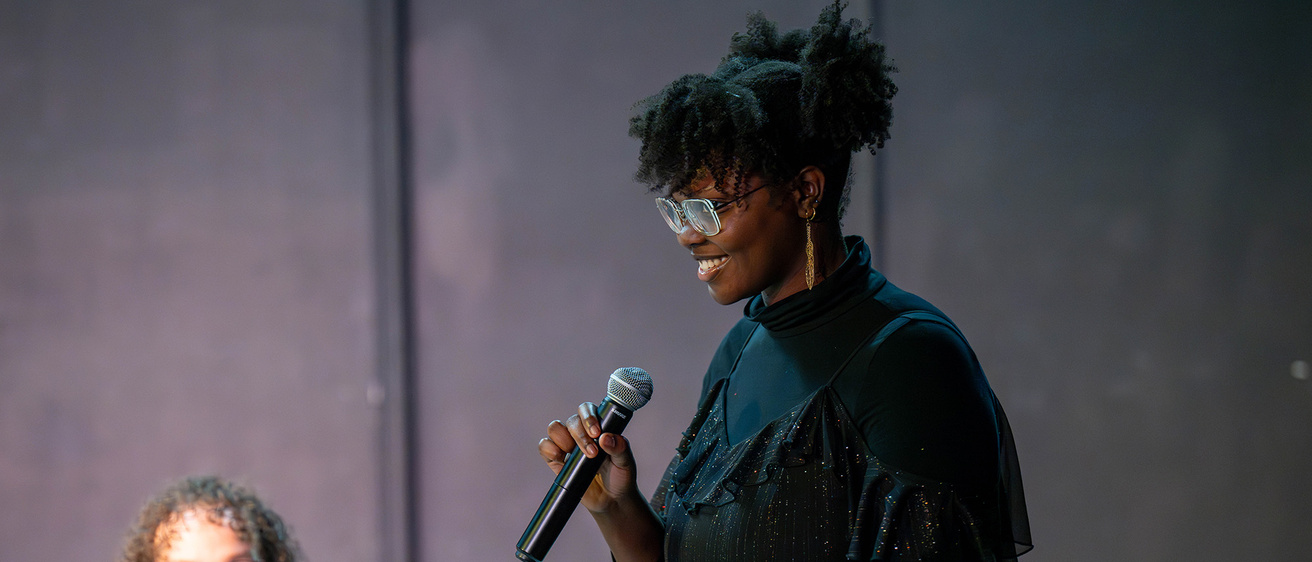 playwright Cianon Jones holds a microphone during a public staged reading of her play