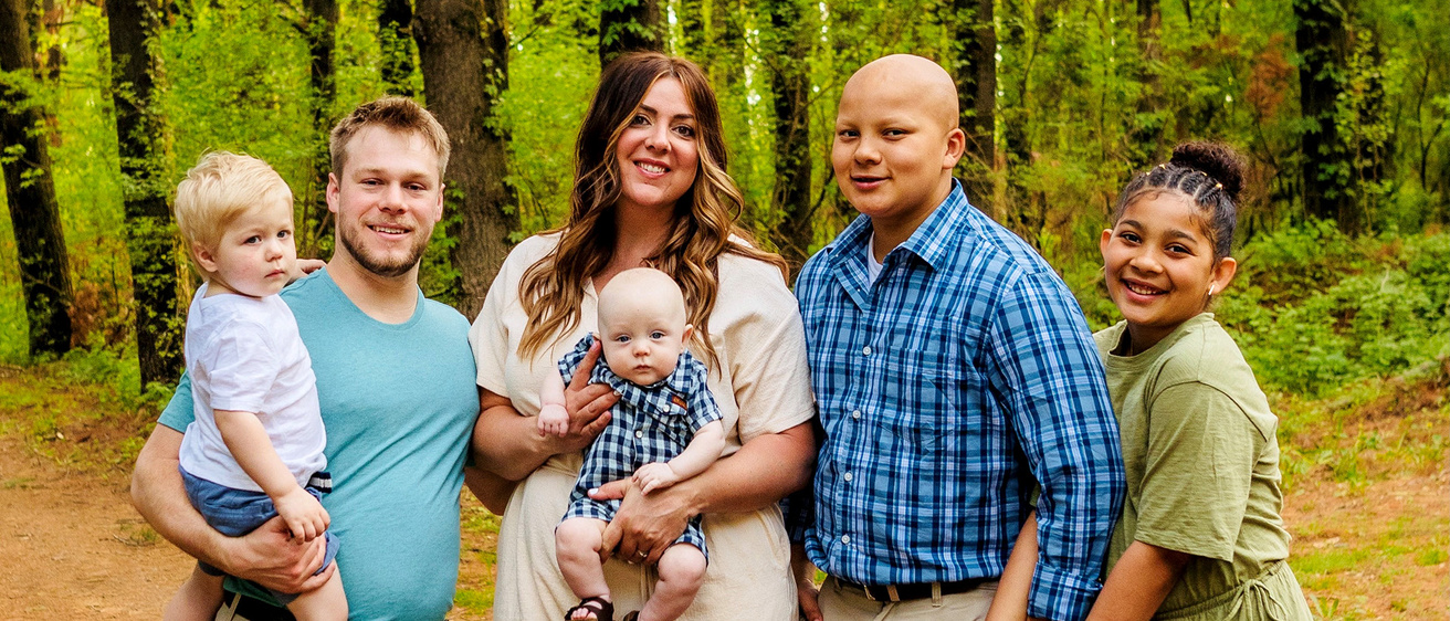 a family of six poses for an outdoor portrait
