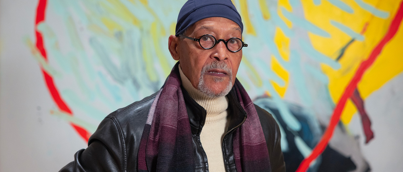 A man standing in front of a colorful mural