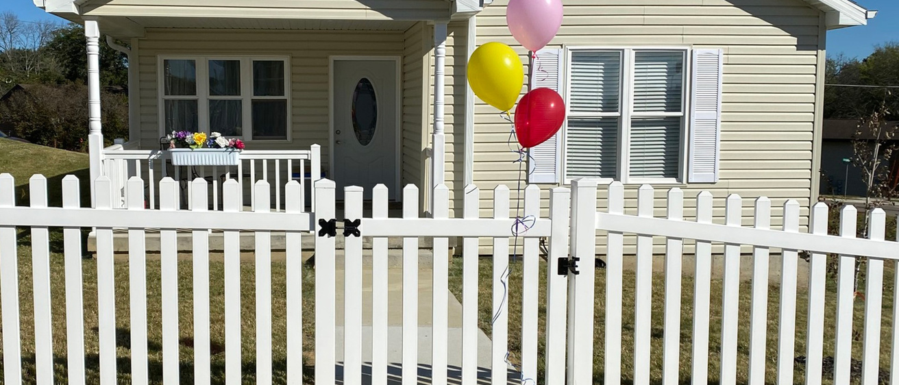 a new house with balloons attached to the front gate