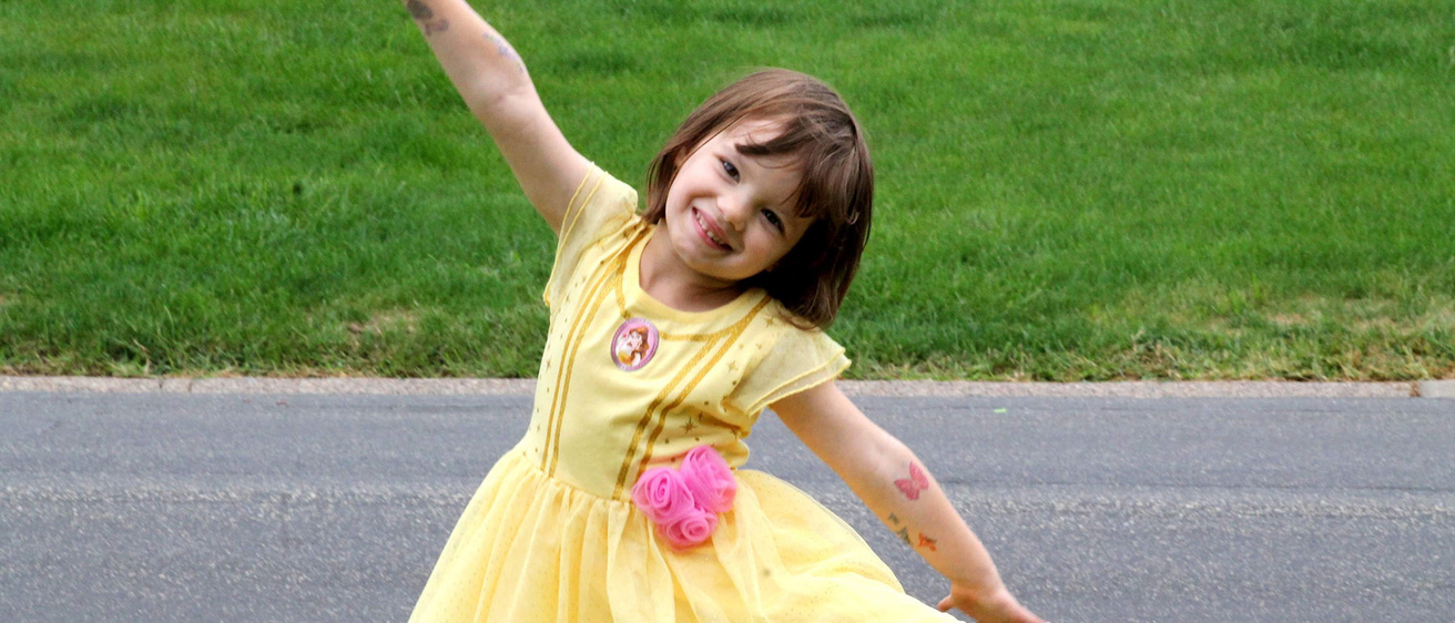 A young girl dancing in a princess dress