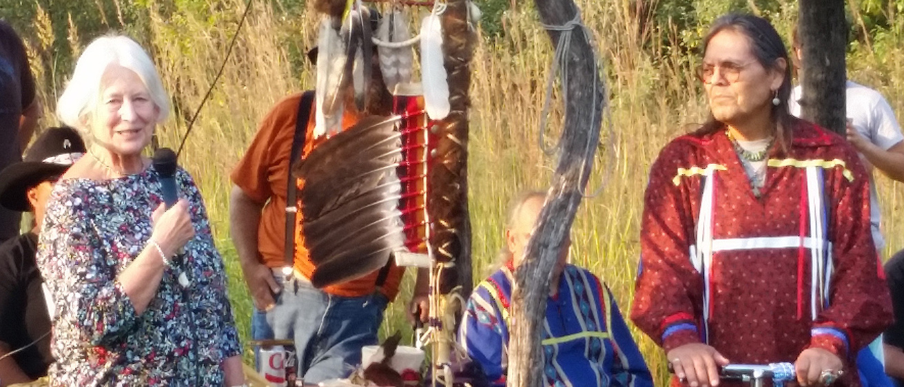 A woman with a microphone talking to a group of people