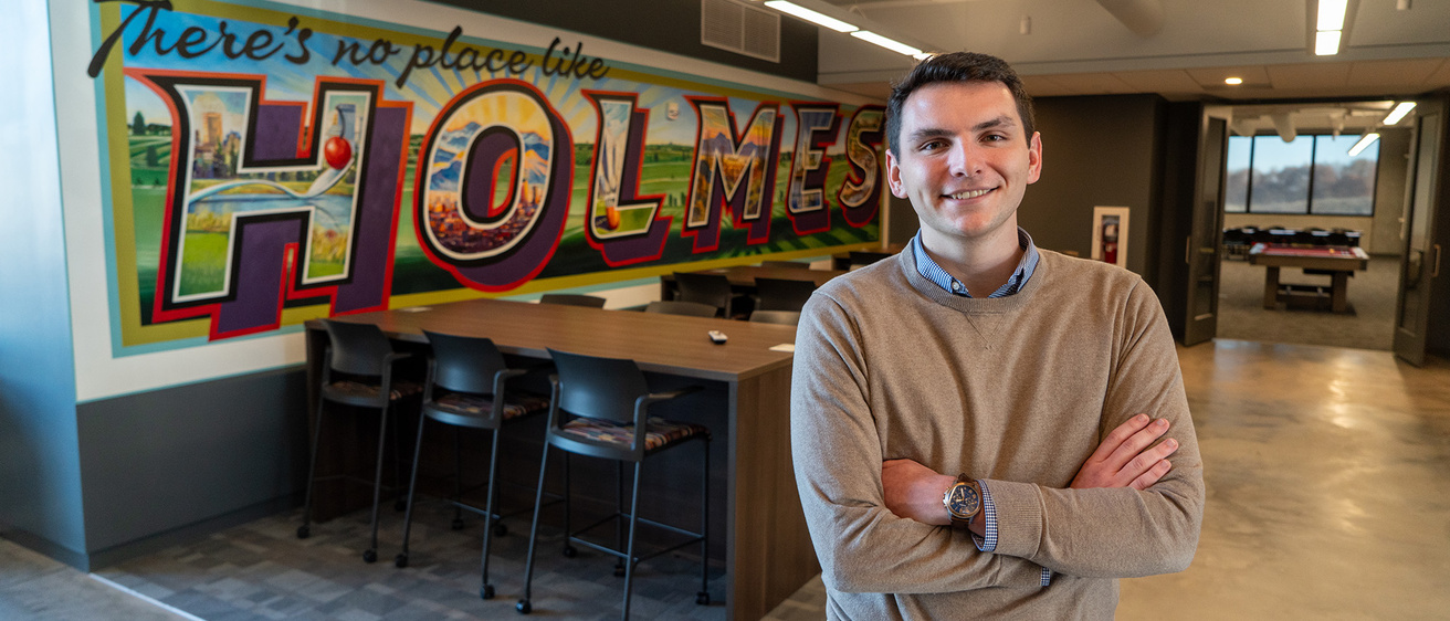 A man standing in an office and smiling