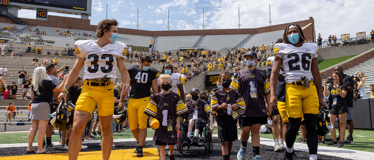 A group of kids walking out on a football field