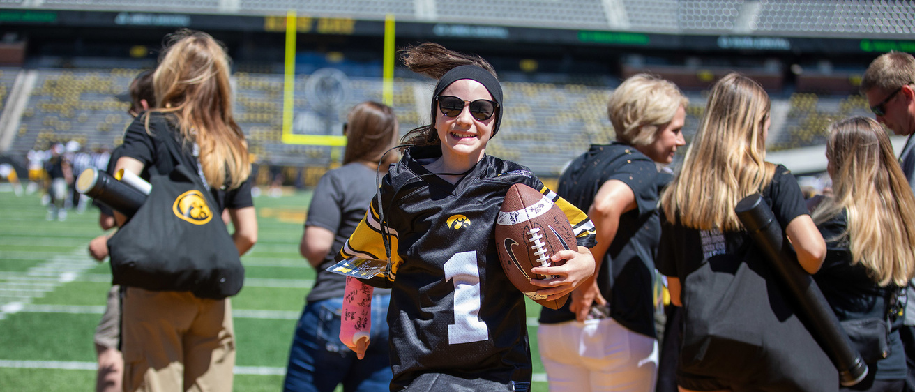 A girl jumping while holding a football