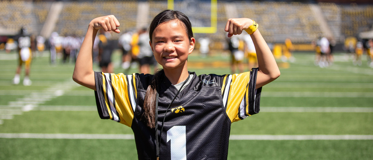 a girl flexing on a football field
