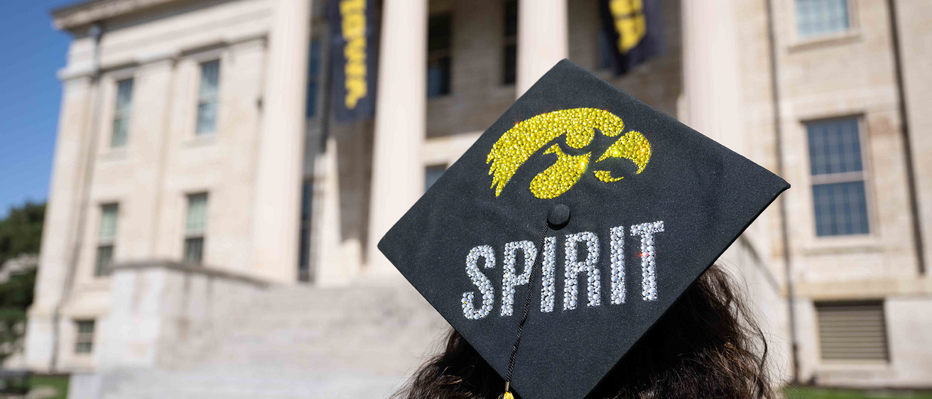 a grad standing near Old Capitol