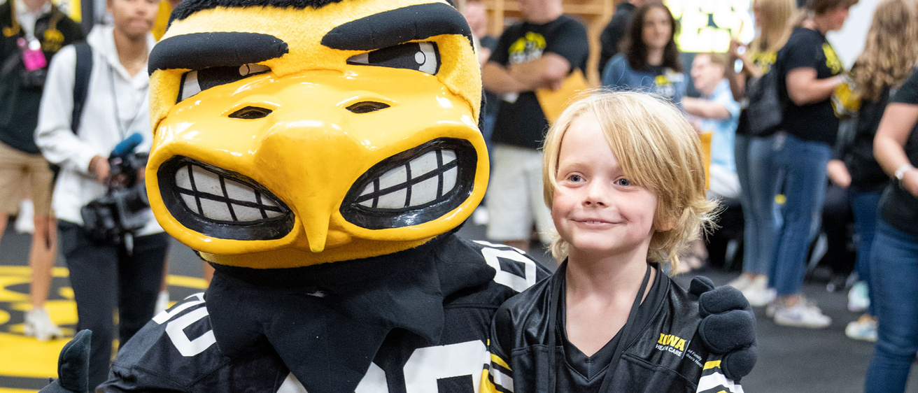 A boy taking a picture with Herky
