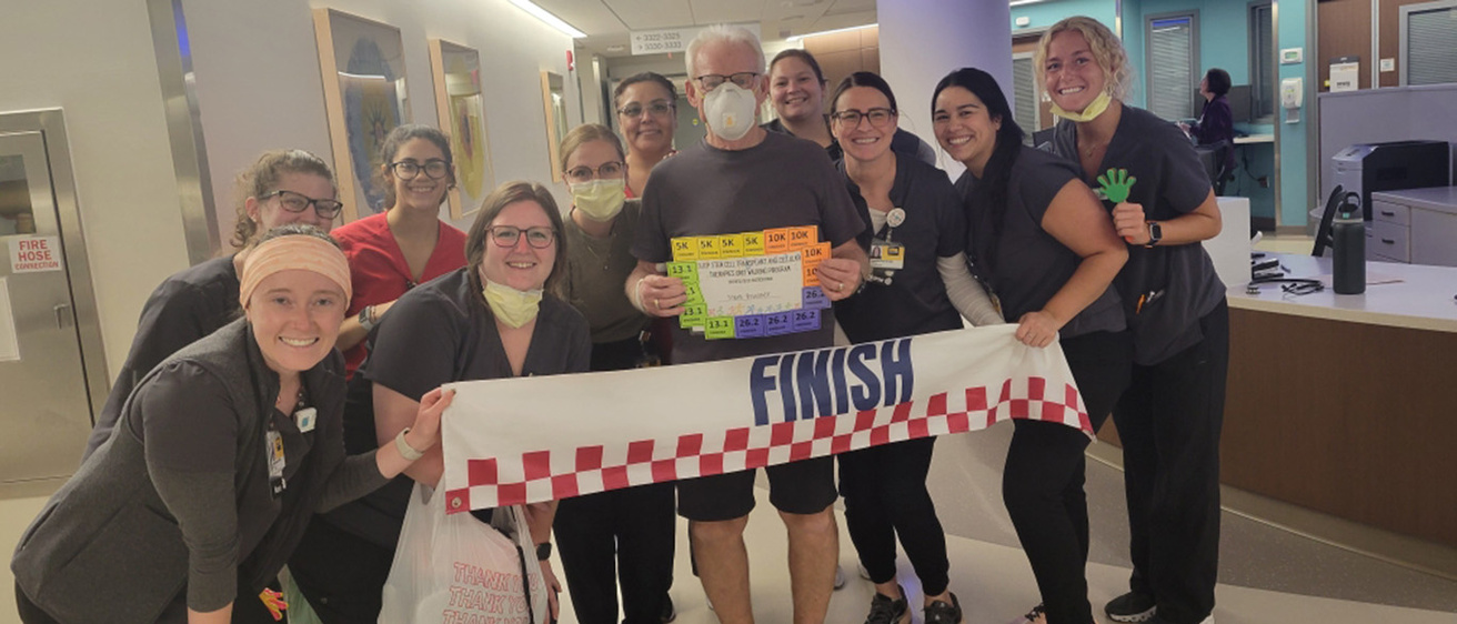 a patient surrounded by nurses after finishing a walking program
