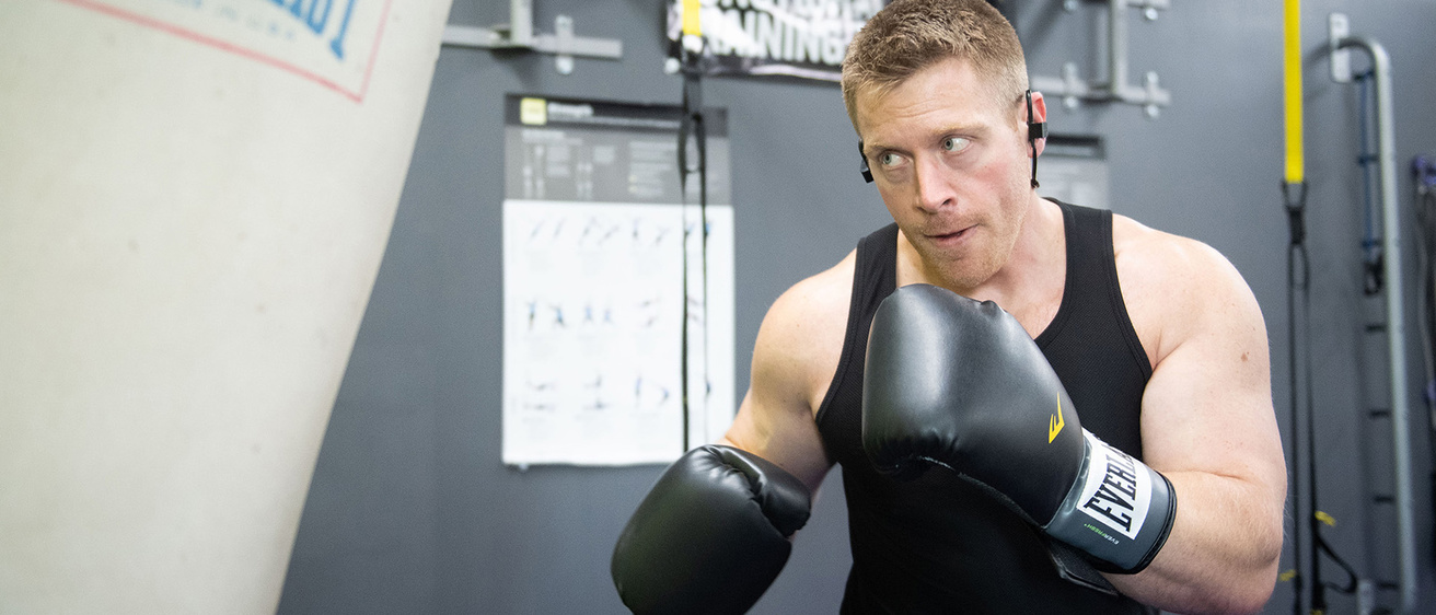 jordan hauck wearing boxing gloves, working out with a heavy bag
