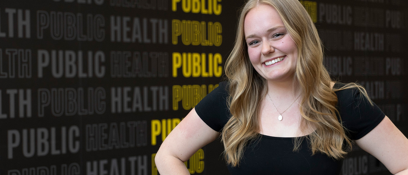 University of Iowa grad Megan Mindy in front of a public health backdrop