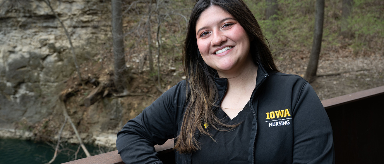 University of Iowa grad Genevieve Martinez standing near the pond by Art Building West