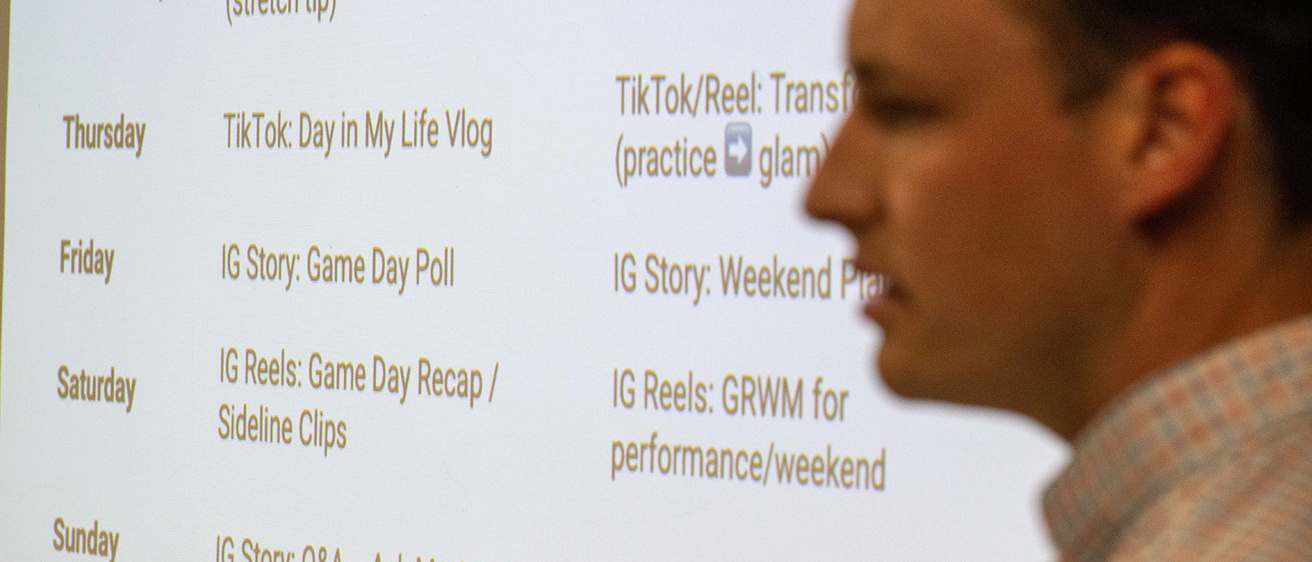 a student giving a presentation to an athlete about a plan for name, image, and likeness
